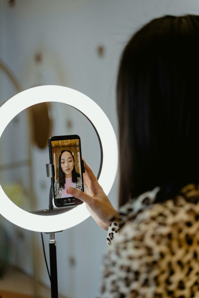 Girl videoing herself in a ring light Dangers of TikTok for teens